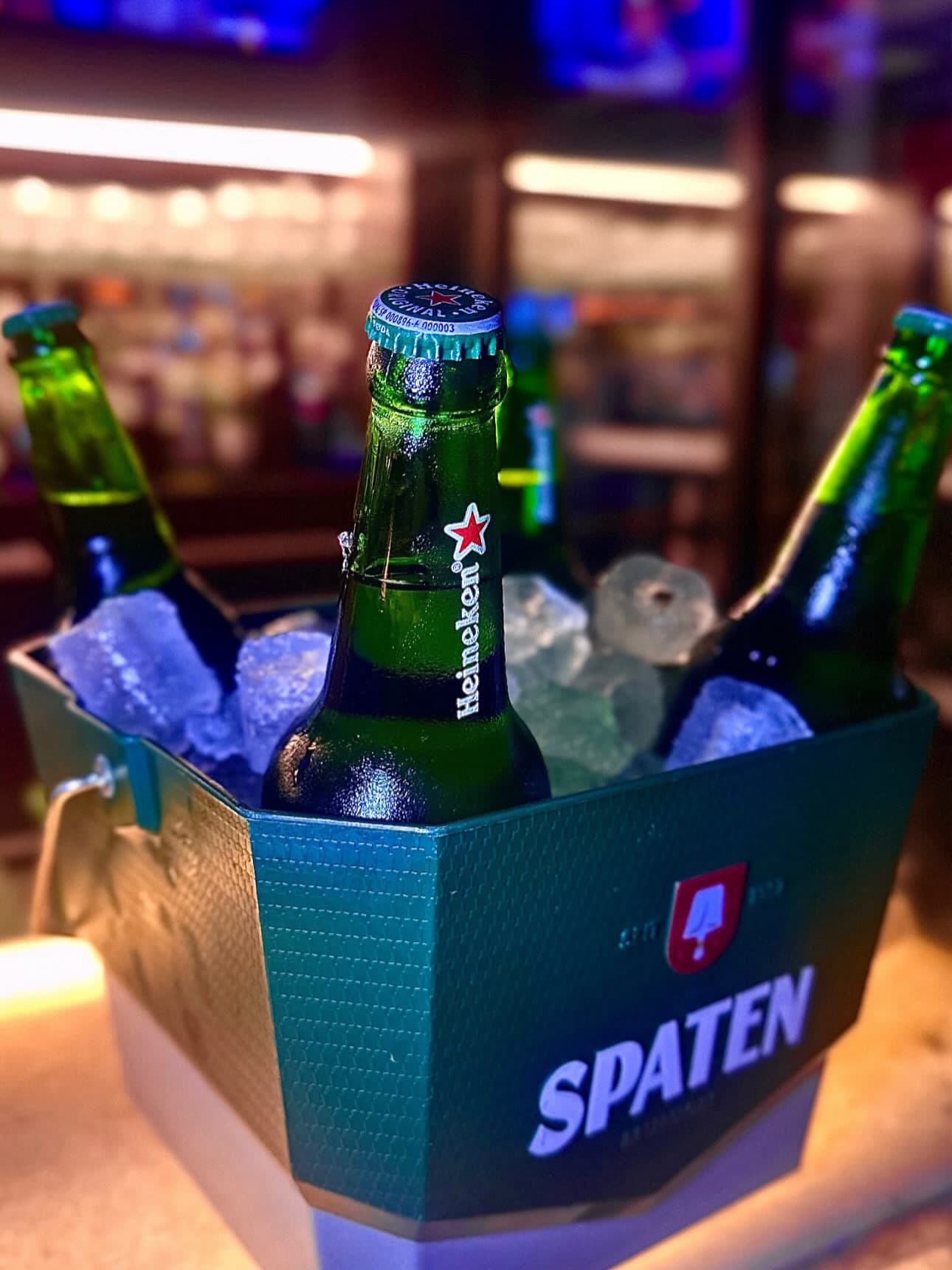 Balde de gelo com long necks de Heineken e Spaten no balcão