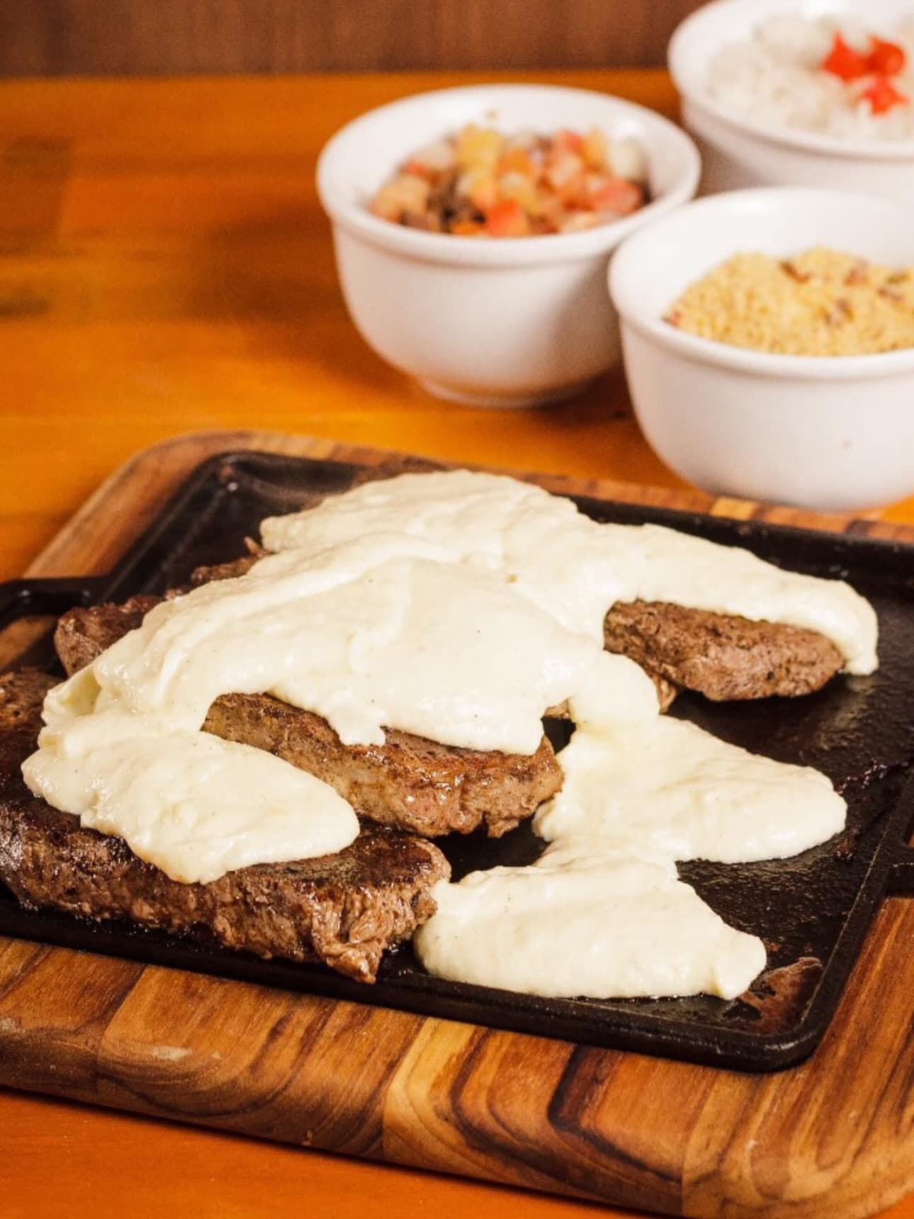 Bife ancho coberto de aligot na chapa, com arroz, vinagrete e farofa